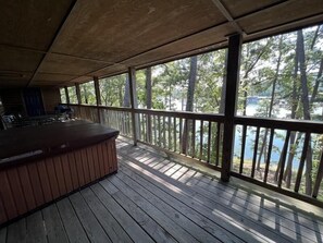 A wooden deck with a bar area and a view of a lake surrounded by trees. - C16, Two bedroom, two bath, log-sided Harbor North luxury cottage with hot tub overlooking Lake Ouachita. by RedAwning (Mount Ida)