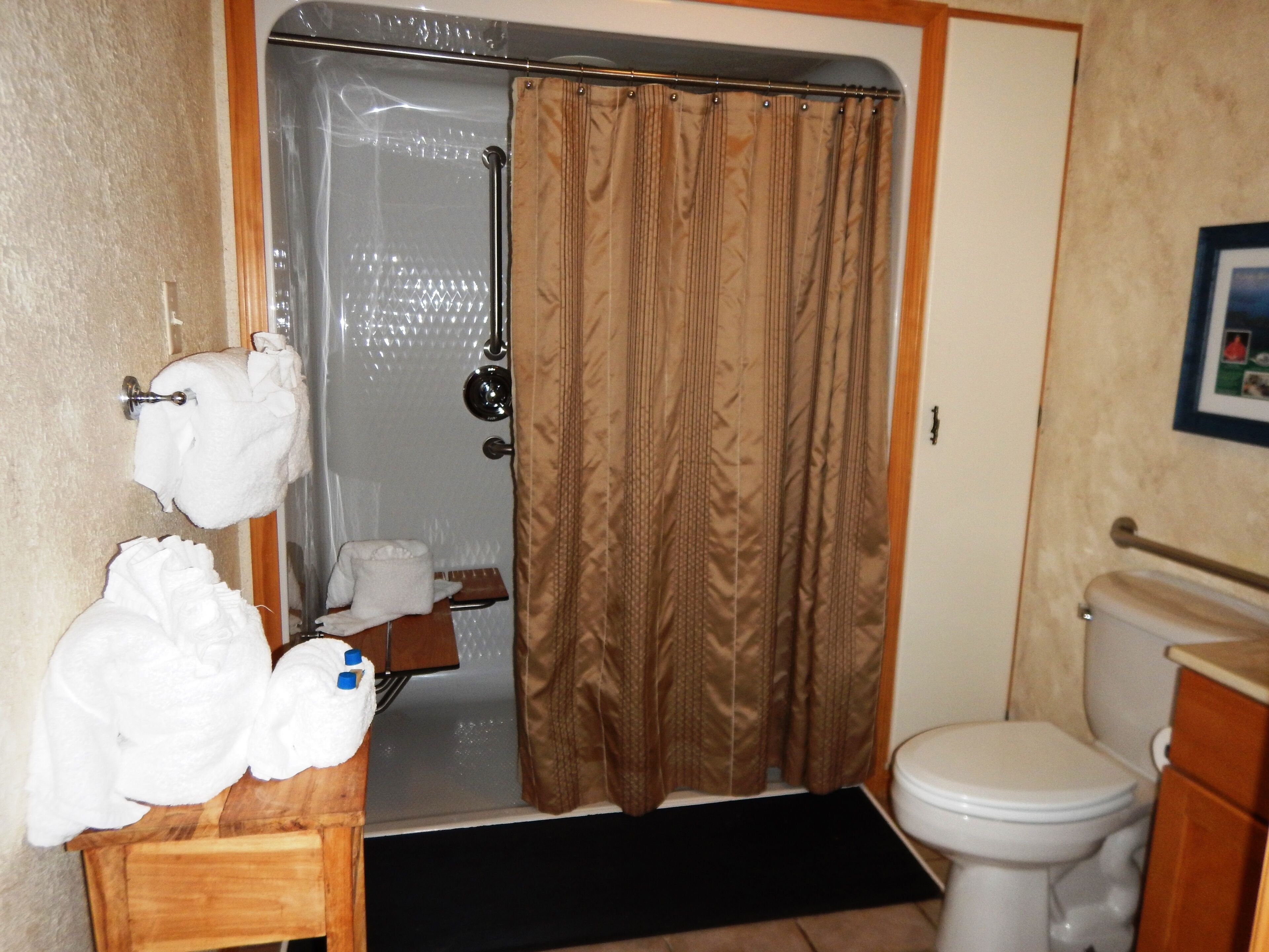 A bathroom with a shower, toilet, and sink.