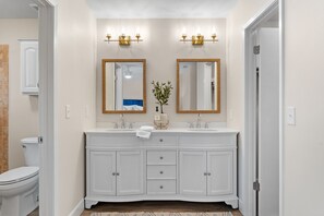 A bathroom with a white vanity, two mirrors, and a plant on the countertop. - Beach Villa w/ 4-Seat GOLF CART! Near Beach & Pool. Screened Porch, Yard (Miramar Beach)