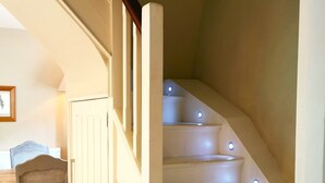 A staircase with white steps and a wooden handrail, leading to an upper floor. - Beautiful, traditional rural cottage (Shrewton)