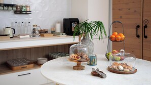Una cucina con un piano di lavoro in marmo, un armadietto in legno e una vetrina in vetro con dolci.