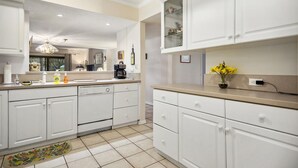 Una cocina moderna con armarios blancos, una isla central y un horno empotrado.