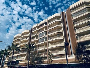 A multi-story building with balconies, palm trees, and a clear sky. - Holiday Apartment "Doña Sofía" with Sea View, Private Terraces & Wi-Fi (Fuengirola)