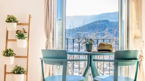 A room with a table and chairs, a view of a mountainous landscape, and a wooden ladder with potted plants. - Holiday Apartment Ca Na Magda with Sea View, Wi-Fi, A/C & Balcony (Port de Sóller)