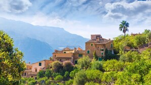 A hillside village with traditional buildings, lush greenery, and mountains in the background. - Holiday Apartment Ca Na Magda with Sea View, Wi-Fi, A/C & Balcony (Port de Sóller)