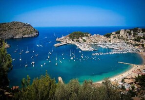 A coastal town with a marina, buildings, and a beach.