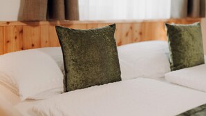 A bed with white linens and two green pillows. - Apartment 'Vernalhof Apt Sunnaseit' with Mountain View, Shared Terrace and Wi-Fi (Sluderno)