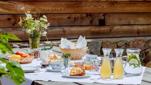 A picnic table with food, drinks, and a basket of bread. - Apartment 'Vernalhof Apt Panorama' with Mountain View, Shared Terrace and Wi-Fi (Sluderno)