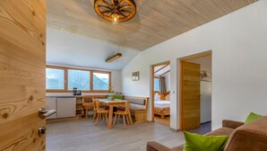 A modern interior with a dining area, wooden furniture, a ceiling fan, and a view of mountains through large windows. - Apartment 'Vernalhof Apt Panorama Large' with Mountain View, Shared Terrace and Wi-Fi (Sluderno)