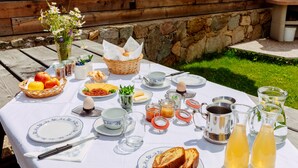 An outdoor dining table set with breakfast items, including bread, eggs, and beverages. - Apartment 'Vernalhof Apt Panorama Large' with Mountain View, Shared Terrace and Wi-Fi (Sluderno)