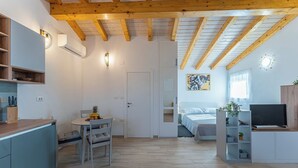 Un espacio habitable moderno y de concepto abierto con cocina, comedor y dormitorio.
