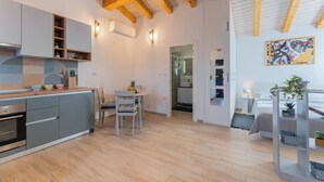 Una cocina moderna con armarios grises, techo de madera y un comedor con mesa y sillas.
