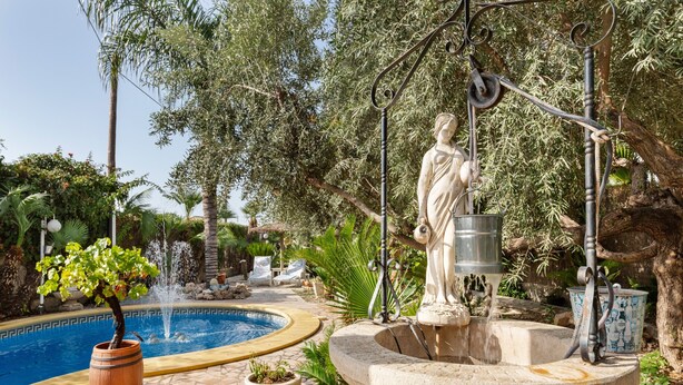 A pool area with a statue, a fountain, and potted plants. - Studio 'Alojamiento Ruizo' with Mountain Views, Shared Pool and Wi-Fi (Lorca)