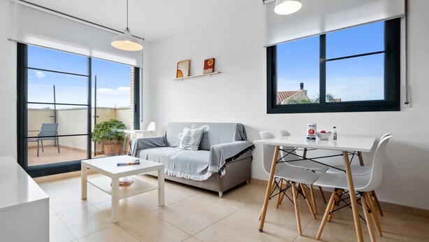 A modern living room with a sofa, coffee table, dining table, chairs, and large windows. - Holiday Apartment "Ferran" with Private Terrace, Balcony & Wi-Fi (Deltebre)