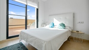 A bedroom with a large bed, a round side table, a view through a sliding door to an outdoor area, and a white ceiling. - Holiday Apartment "Ferran" with Private Terrace, Balcony & Wi-Fi (Deltebre)