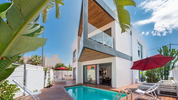 A modern two-story house with a swimming pool, outdoor seating, and tropical plants. - Villa "Can Olivera" close to the Sea with Private Pool & Wi-Fi (Ibiza)