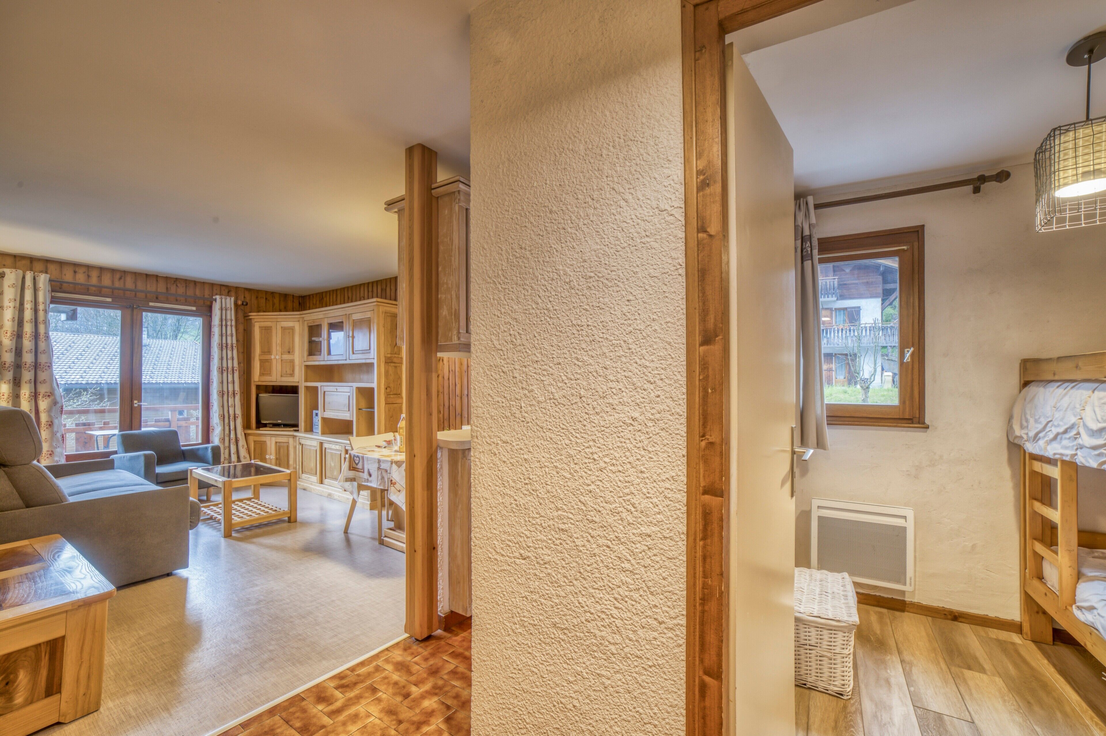 Une pièce confortable avec un canapé, une télévision, des meubles en bois et une fenêtre.
