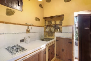 A kitchen with a gas stove, sink, and wooden cabinets. - Country House 'Bentayga Sensation' with Private Pool (Tejeda)