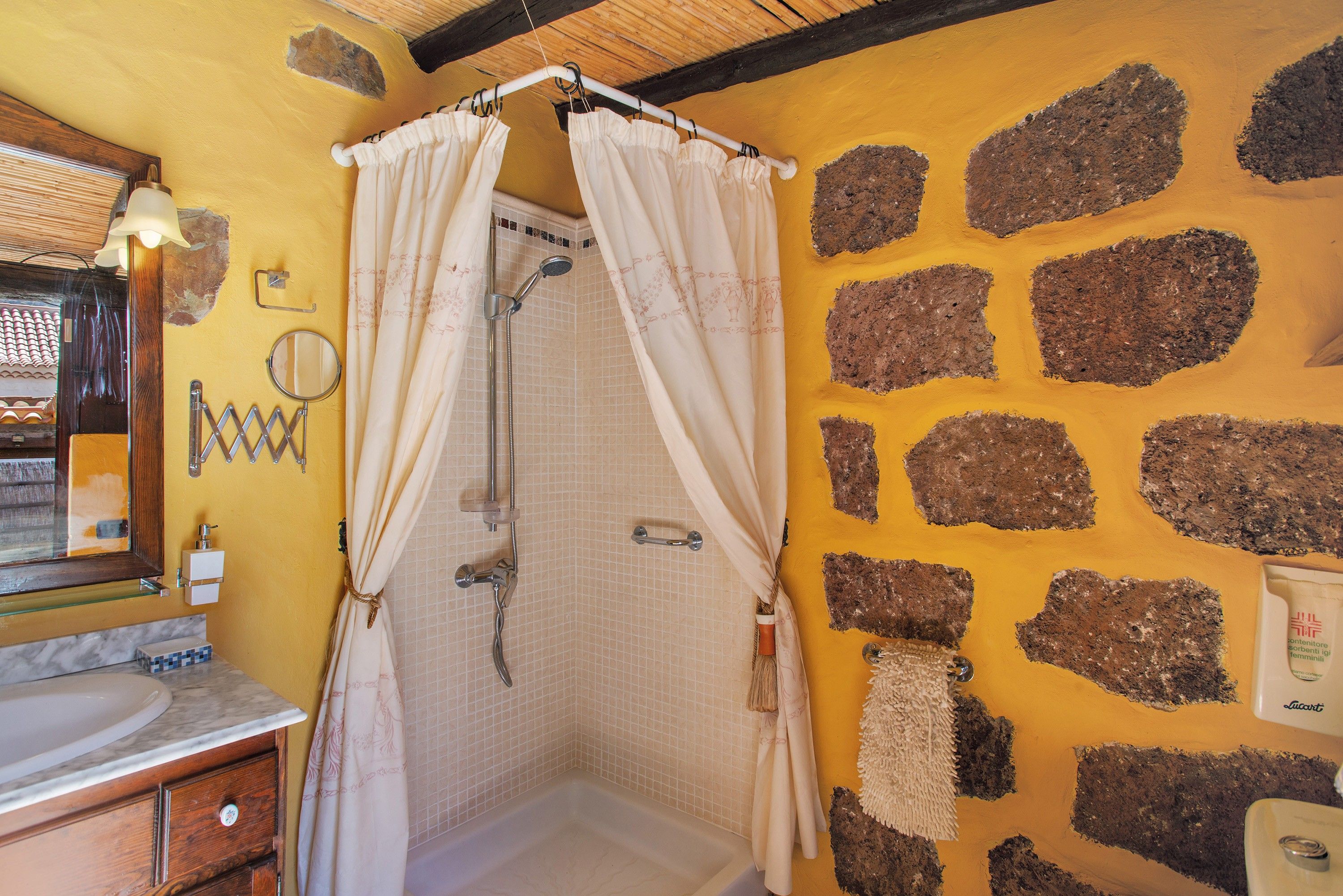 A bathroom with a shower, a mirror, and a sink.