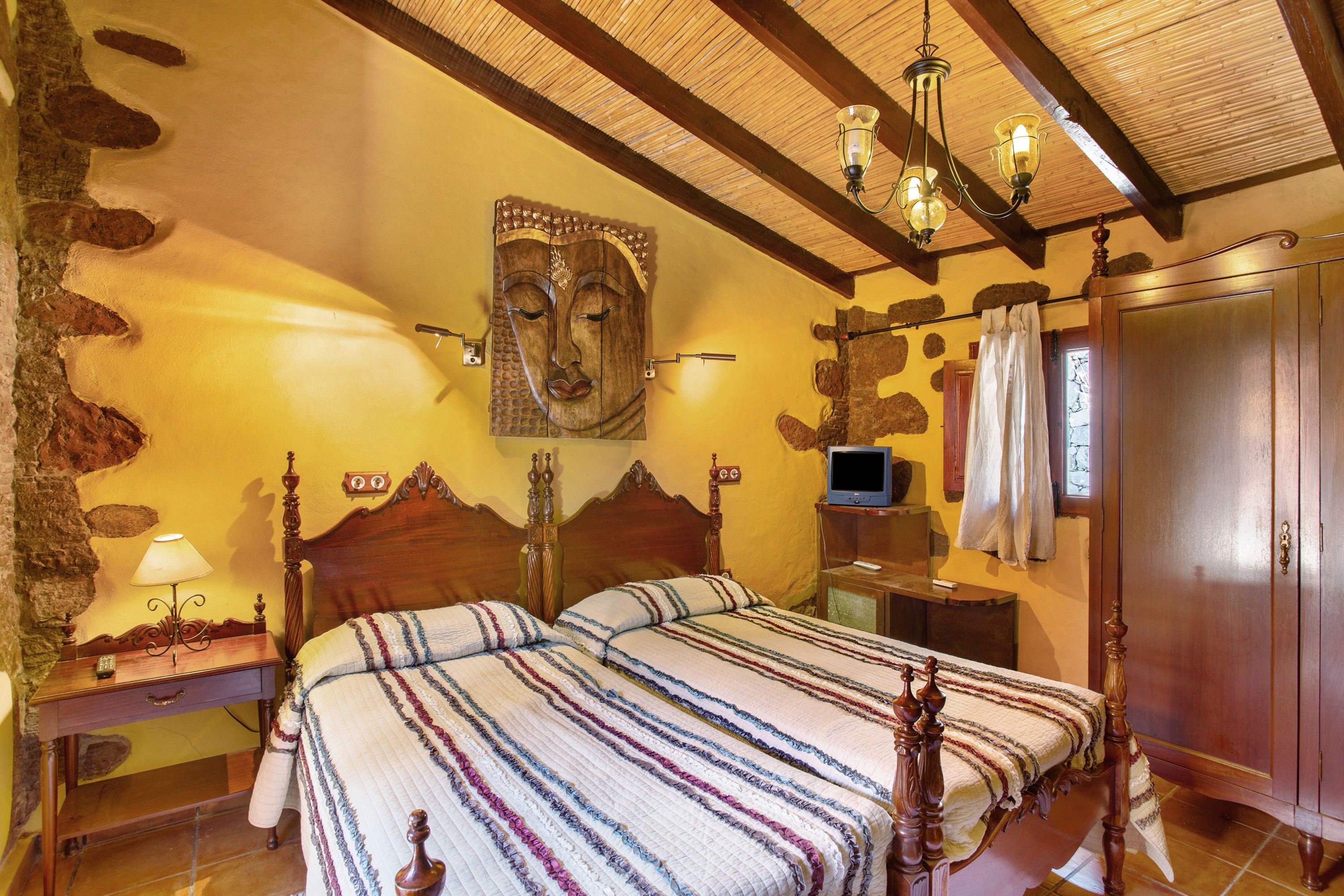 Een kamer met een houten bed, een televisie en een kunstwerk aan de muur.