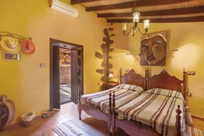 Un dormitorio con una cama de madera, una estatua de Buda en la pared y una decoración de estilo rústico.