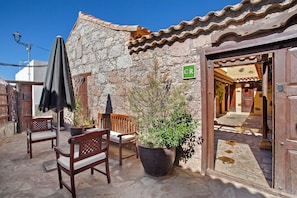 A stone building with a tiled roof, a wooden bench, a potted plant, and a sign with the letter 'CR'. - Country House 'Bentayga Sensation' with Private Pool (Tejeda)