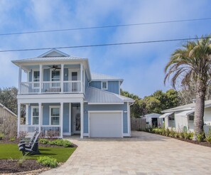 A two-story house with a front porch, a garage, and a well-maintained lawn.