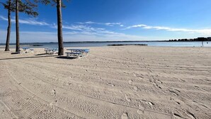 A beach with sand, trees, and a clear sky. - Large home-marina, beach, pools (Long Neck)