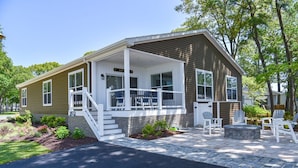 A single-story house with a porch, a stone fireplace, and outdoor seating. - Large home-marina, beach, pools (Long Neck)