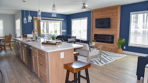 A modern kitchen with a central island, wooden cabinets, and pendant lighting. - Large home-marina, beach, pools (Long Neck)