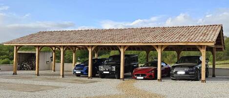 Una zona de estacionamiento techada con suelo de grava.
