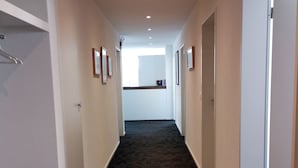 A hallway with carpeted floors, white walls, and recessed lighting. - Ferienwohnung Hirschen (Gossau)