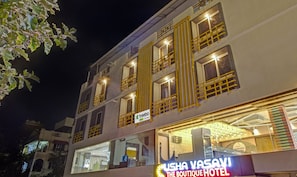 Un hotel de varios pisos con balcones, un letrero visible de 'treebo' y un letrero que dice 'USHYA VASAVI THE BOUTIQUE HOTEL'.