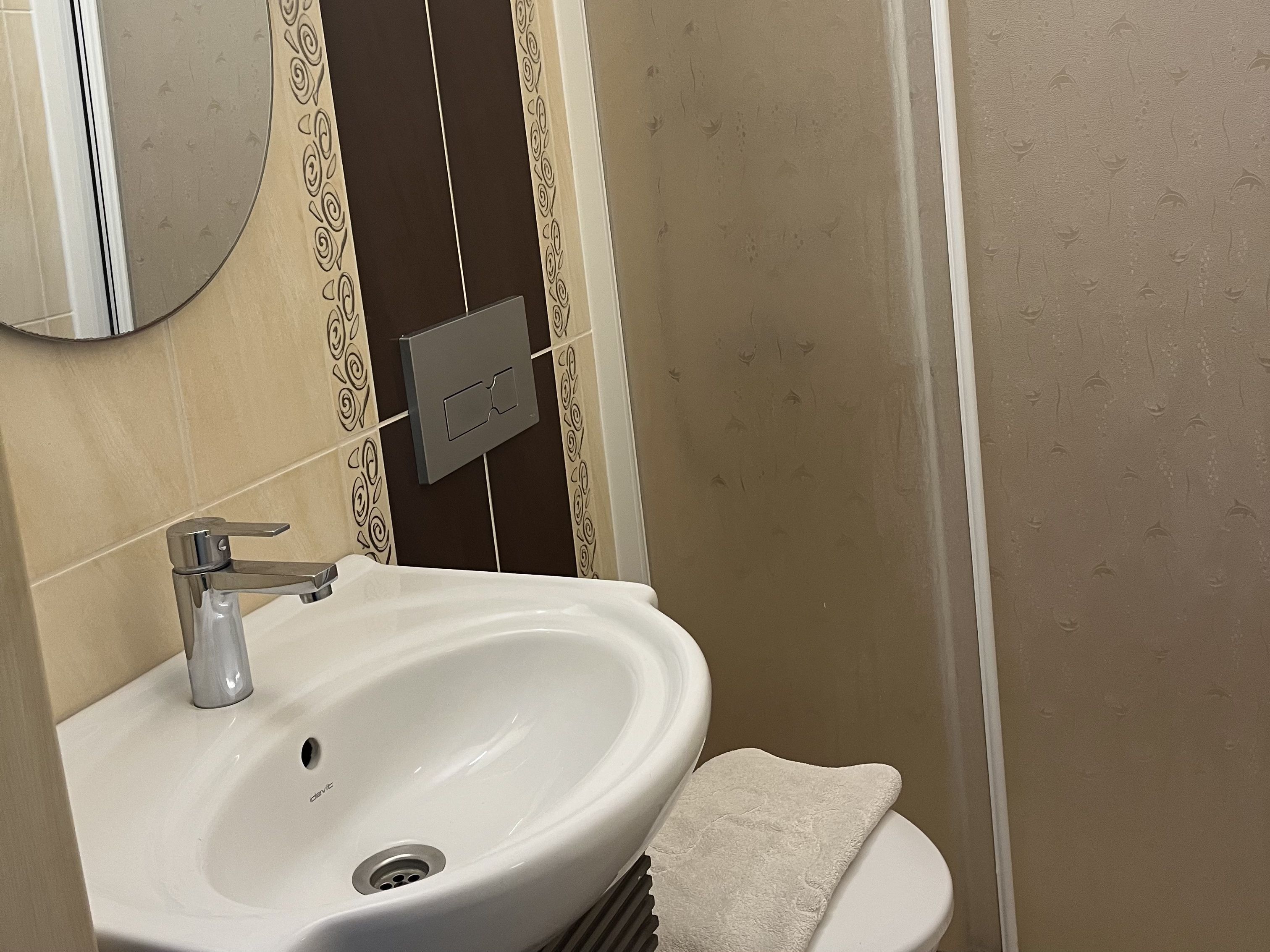 A bathroom with a white sink, a mirror, and a towel.