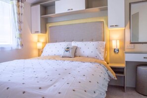 Relax in a cozy retreat with a neatly made bed, bedside tables, and a spacious headboard.