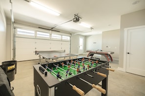 A room with a foosball table, a ping pong table, and a table tennis table. - Stoney Mountain View’s One (Hendersonville)