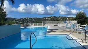 A swimming pool with a view of a hilly landscape and a fenced area with lounge chairs. - Updated 1BR/1BA - "Hillside Getaway" (Lovenlund)