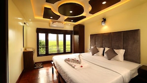 A bedroom with a large bed, a headboard, a window with a view of greenery, and a ceiling with circular light fixtures. - Double Decker Houseboat (Ambalapuzha)