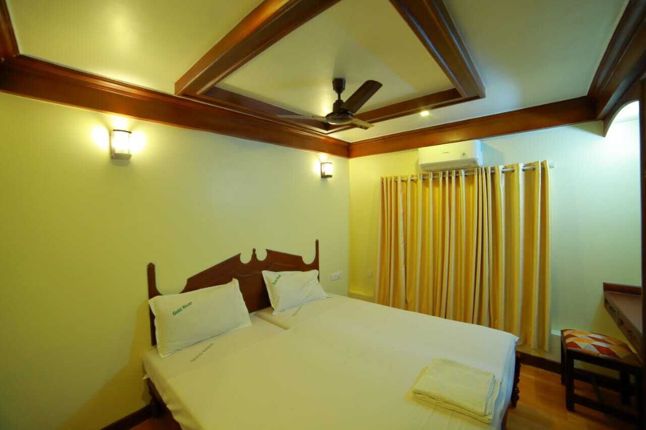 A hotel room with a bed, a ceiling fan, and a window with curtains.