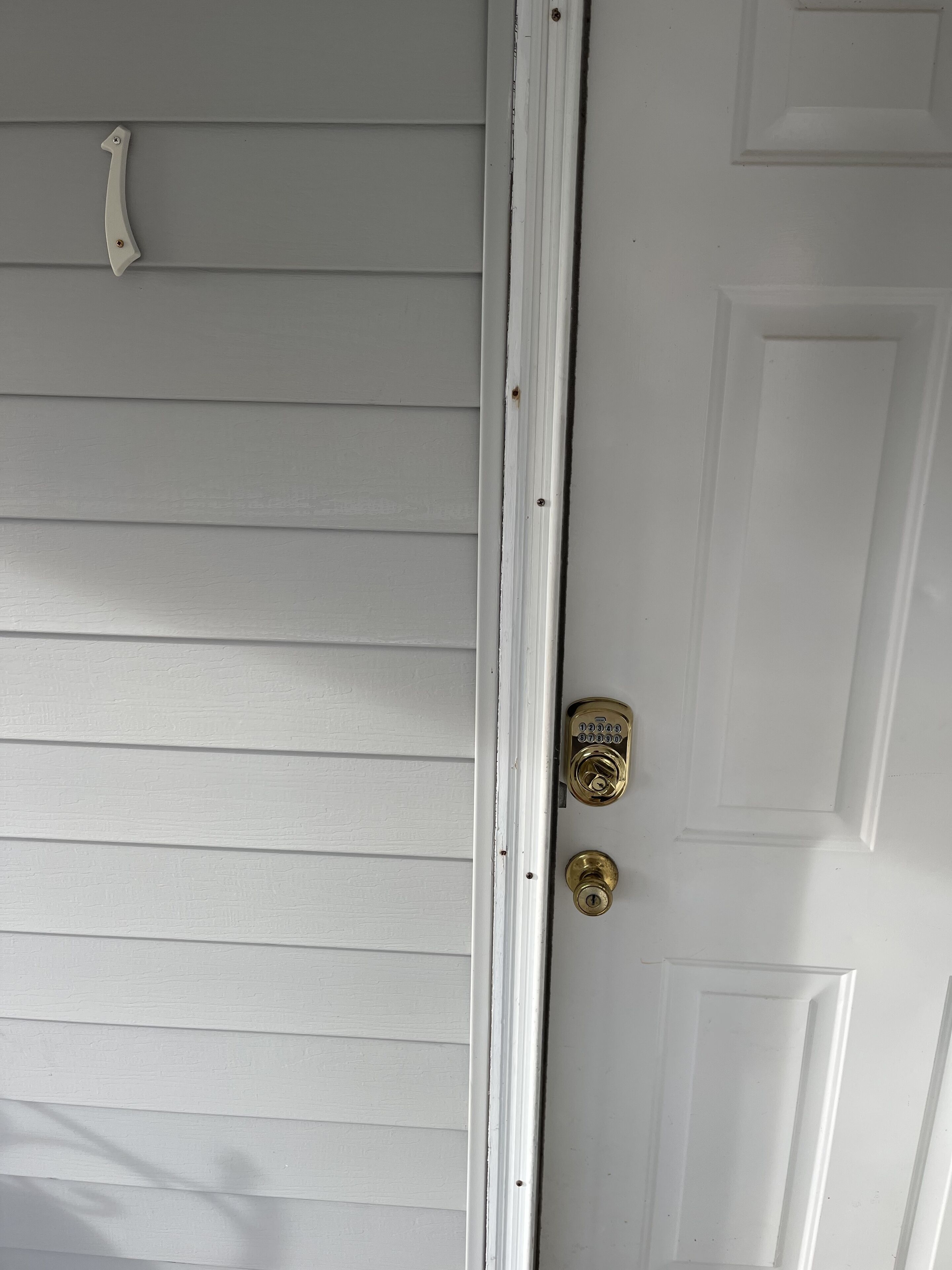 Une porte blanche avec une poignée de porte en laiton et un trou de serrure.