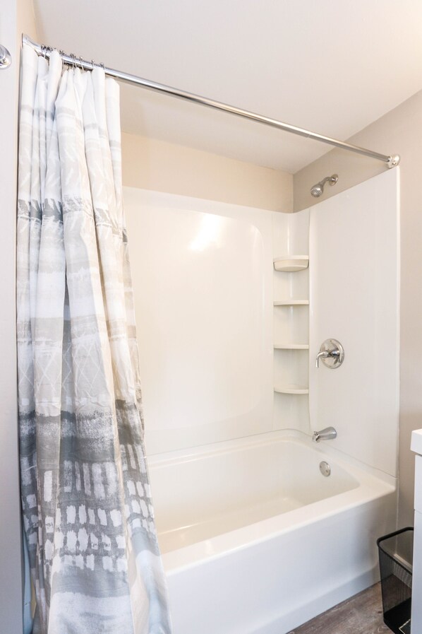 Une salle de bain moderne équipée d’une baignoire, d’une douche et d’une paroi de douche en verre.