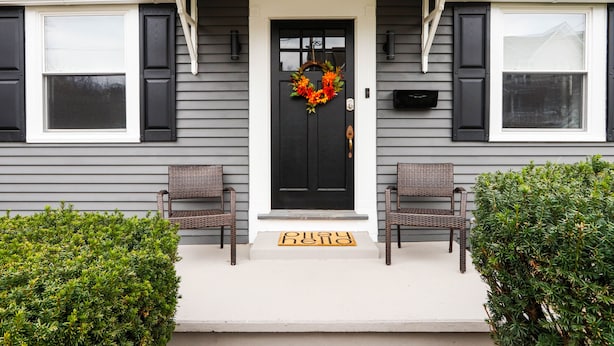 A house with a black front door, a wreath, and a welcome mat. - Christmas City Cottage (Bethlehem)