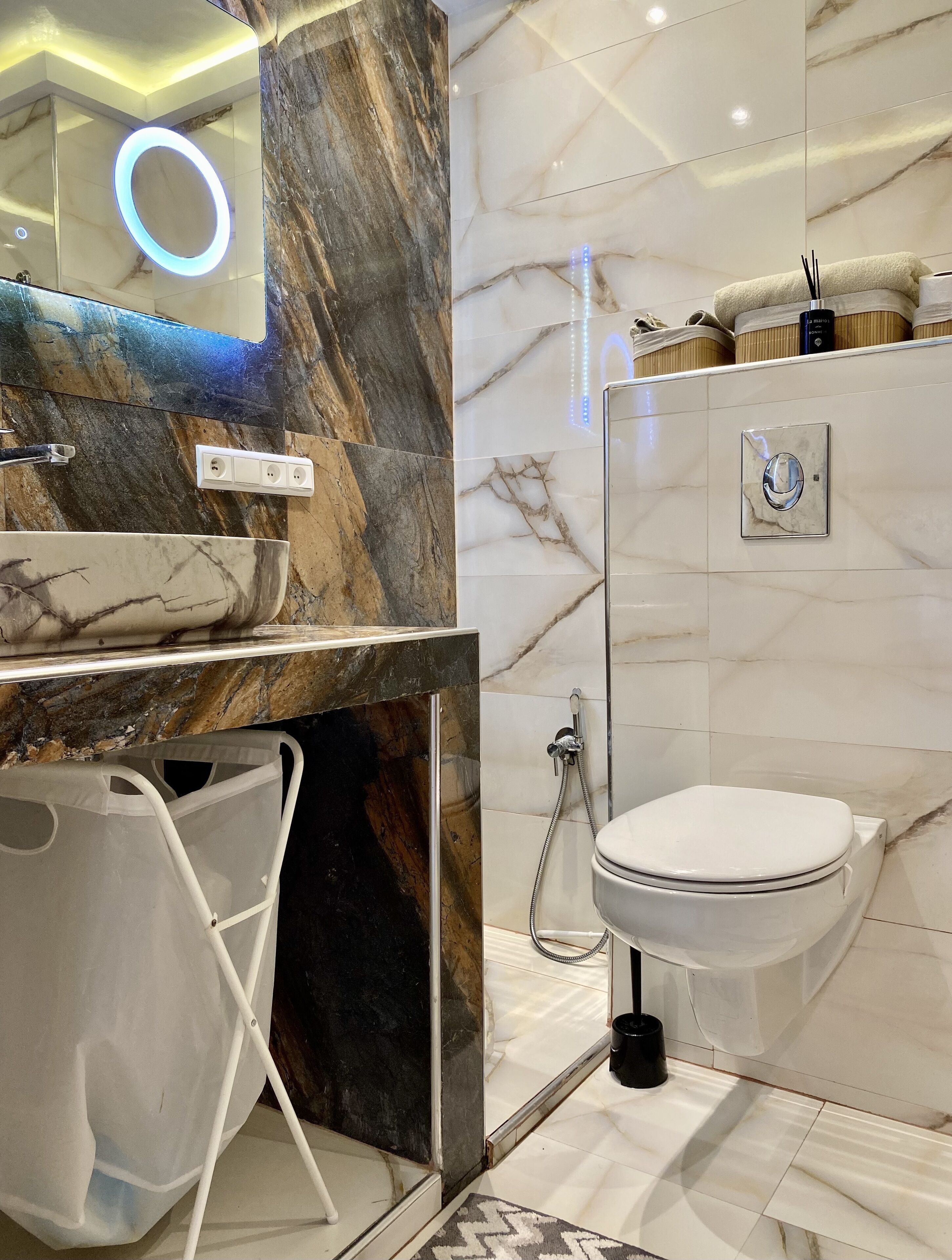 Un baño moderno con tocador de mármol, inodoro y ducha.