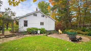 Una casa blanca amb terrassa coberta i jardí.