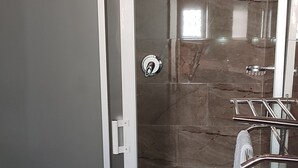 A bathroom with a glass shower enclosure, a towel rack, and a toilet. - Topaz Villas (Lilongwe)