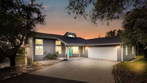 A two-story house with a garage, a front porch, and a driveway. - Canyon Cottage - 1 Acre w/Fire Pits & Game Room! (Canyon Lake)