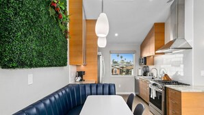 A modern kitchen with a built-in stove, microwave, and stainless steel range hood. - 7BD Family, Event Friendly 5min 2 Beach, Boardwalk (San Diego)