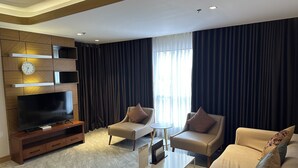 A modern living room with a flat-screen TV, two sofas, a coffee table, and a TV stand.