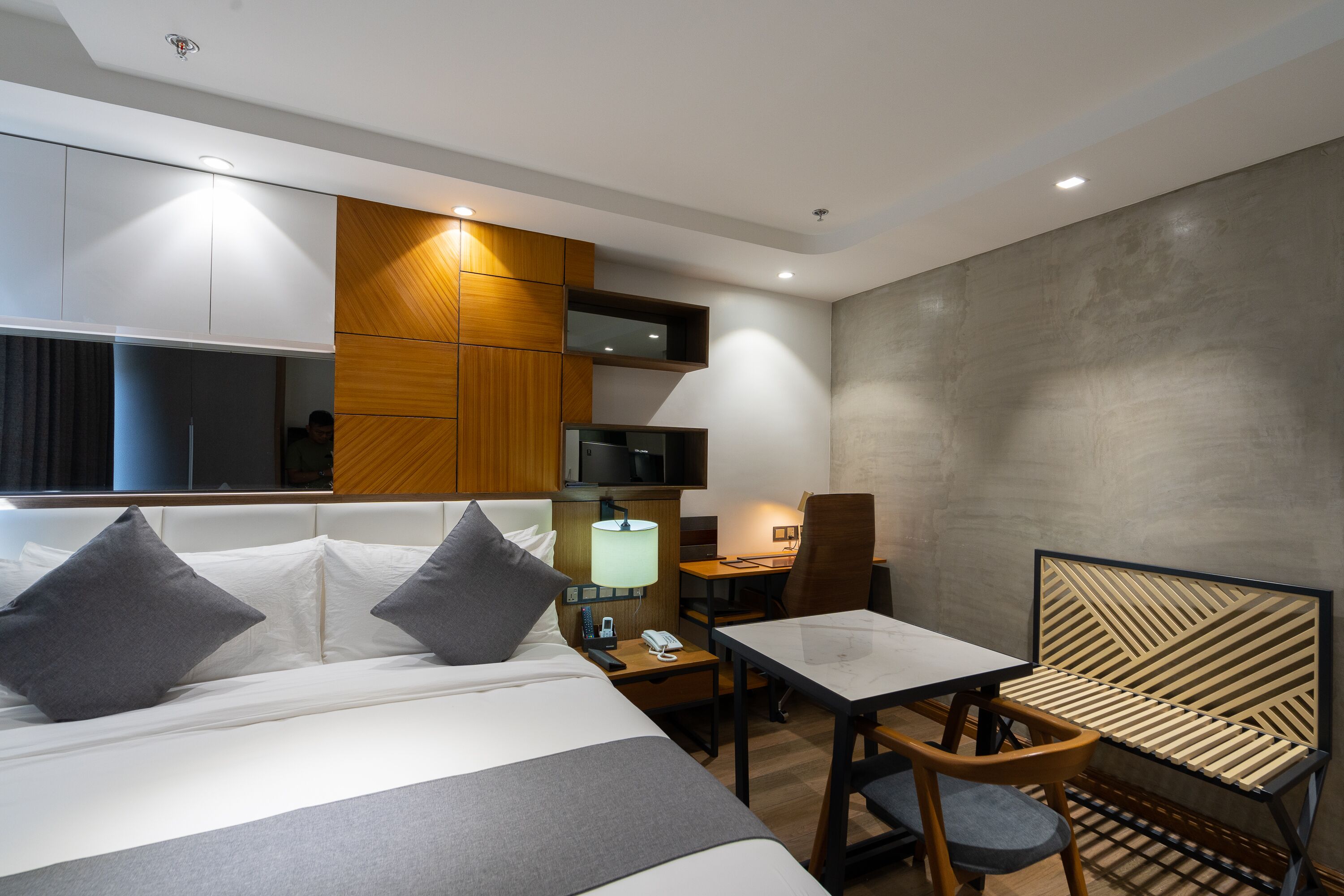 Une chambre d’hôtel moderne équipée d’un grand lit, d’un bureau, d’une chaise et d’une télévision.