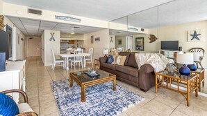 A living room with a sofa, coffee table, and dining area.